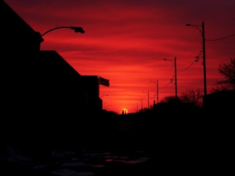 Flick International Desolate street at sunset with an American flag at half-mast