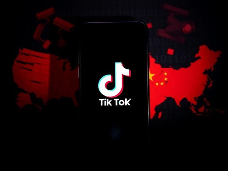 Flick International Darkened smartphone screen displaying TikTok logo surrounded by symbols of digital disinformation and espionage